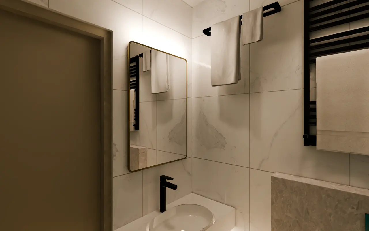 A bathroom with marble wall tiles, a brass-framed mirror over a white basin, black taps and towel rails hung with white towels.